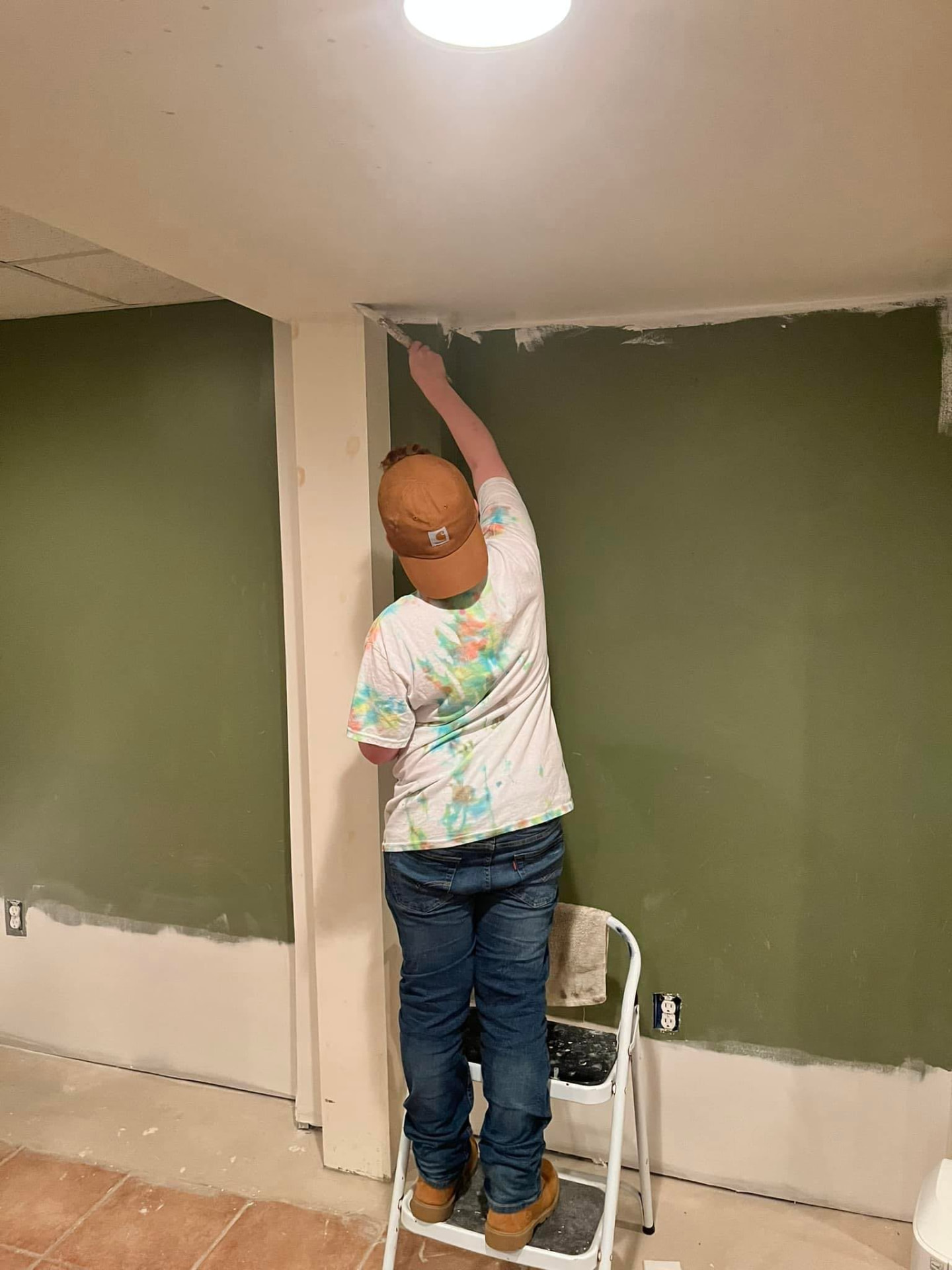 Drywall and spackling work in progress on a green interior wall by R4 Custom Finishes